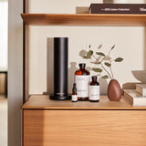 AromaTech ingredientes The Hotel sobre mesa con ramas de pino y flores