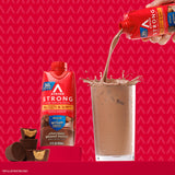 Atkins envase sostenido en mano ilustrando conveniencia para llevar y consumir