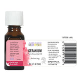 Aura Cacia frasco 15 ml mostrado junto a una moneda para comparar tamaño