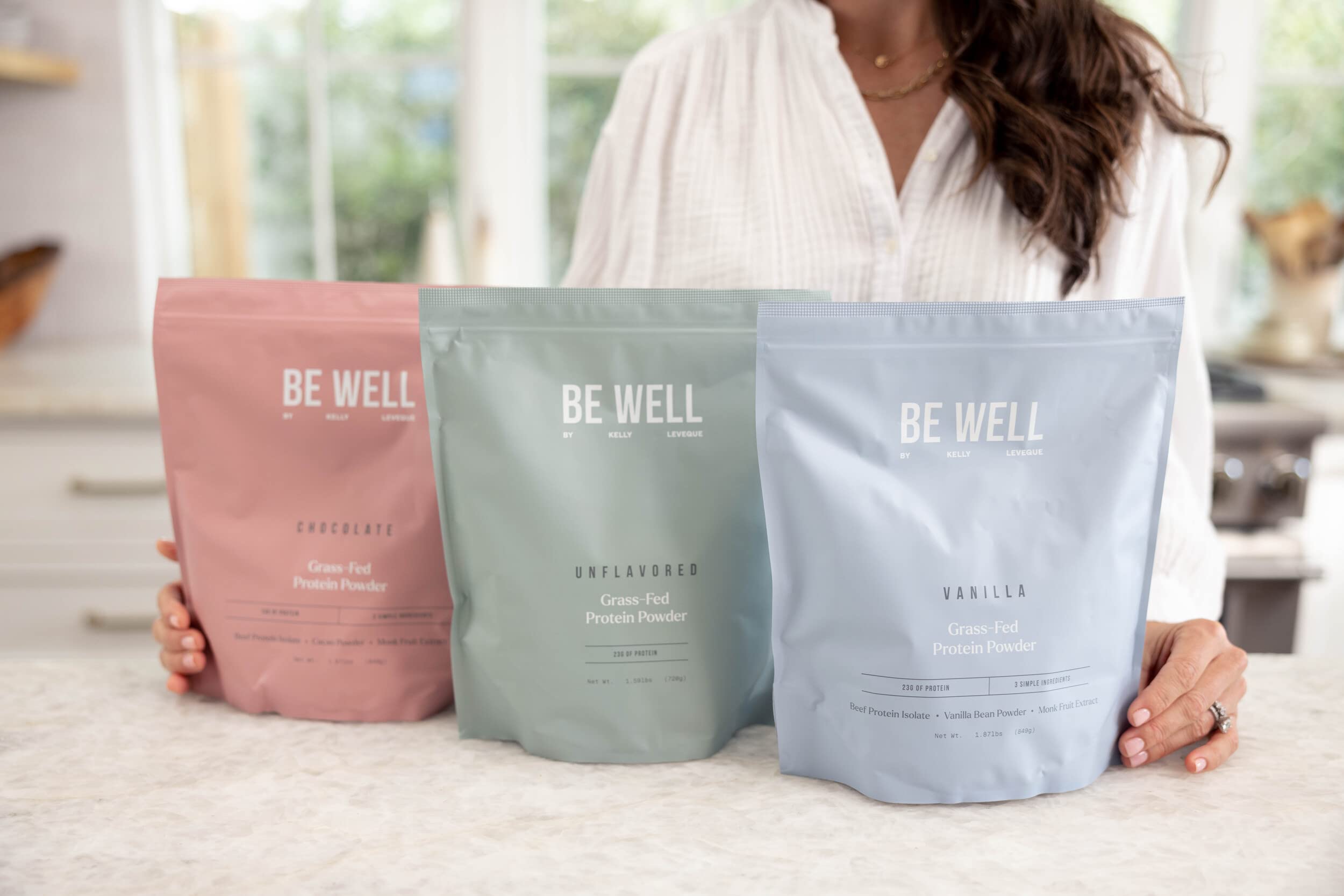 Be Well by Kelly frasco y caja sobre fondo claro que muestran presentación completa