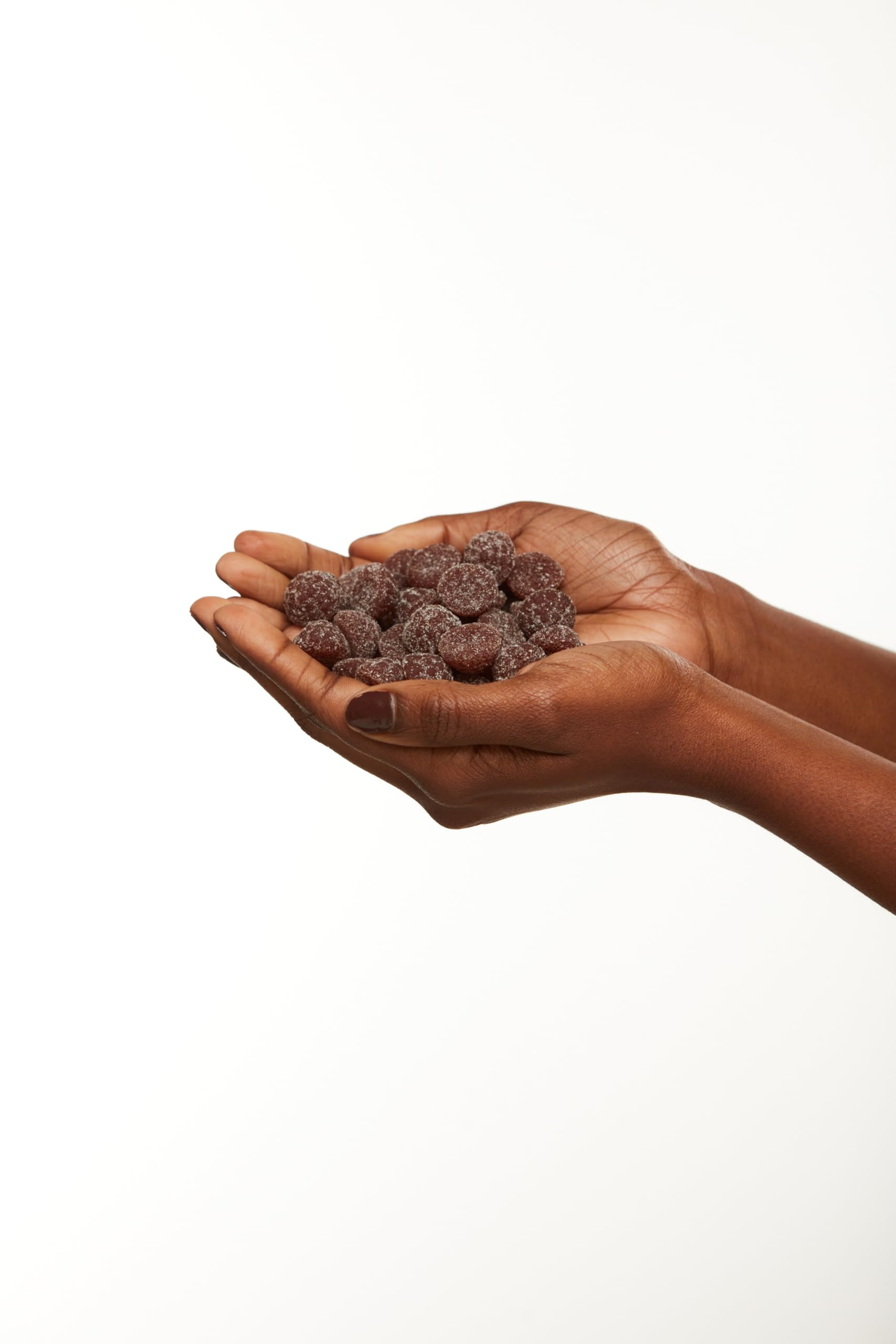 Black Girl Vitamins gominola en mano para comparar tamaño y facilitar consumo