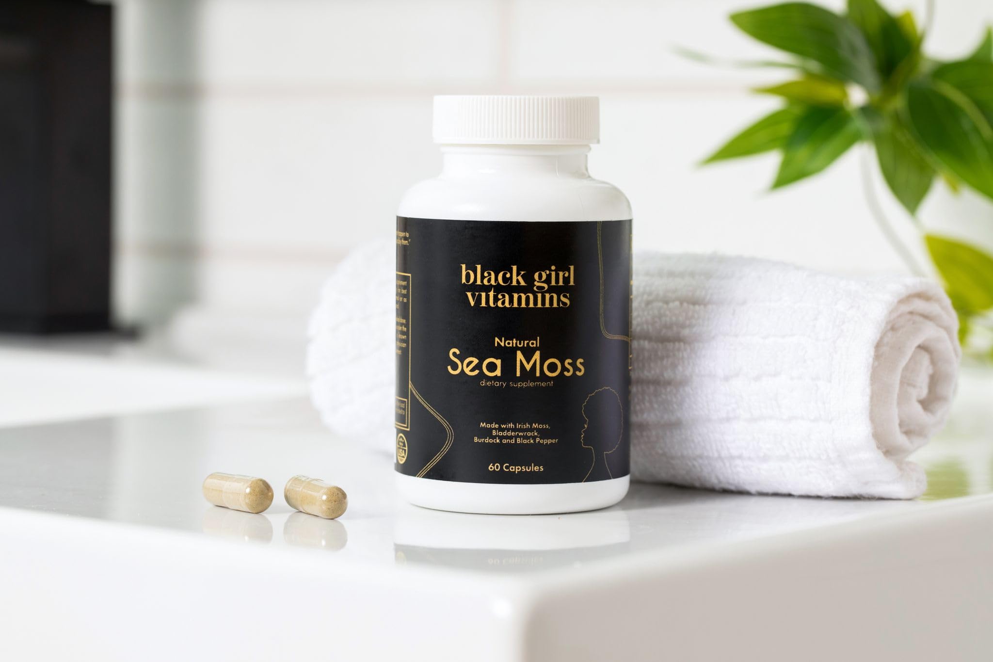 Black Girl Vitamins cápsula junto a regla para comparar tamaño real