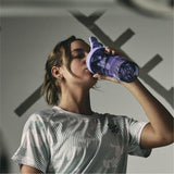 BlenderBottle junto a una botella de agua para comparar tamaño, formato compacto