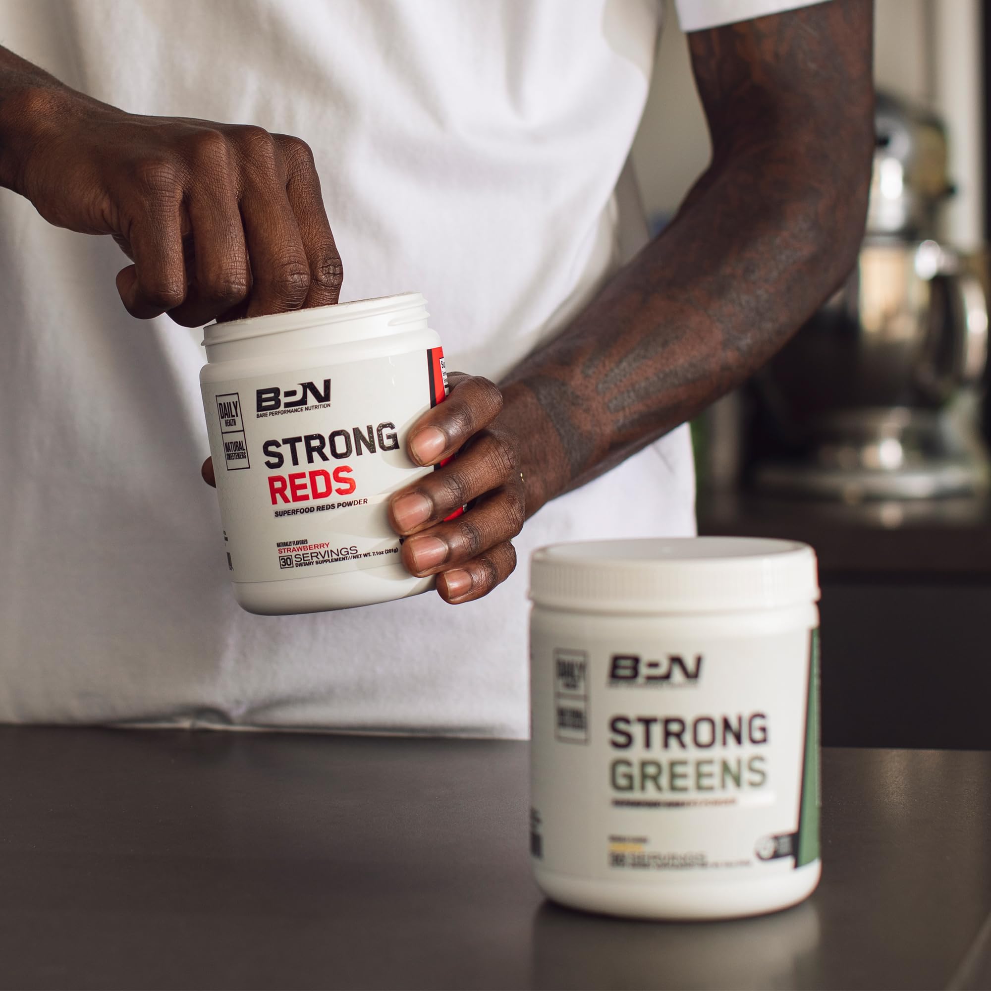 BARE PERFORMANCE NUTRITION estilo de vida matutino con Strong Greens en la mesa, apoya rutina activa