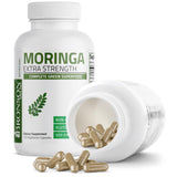 Persona tomando Bronson Moringa cápsula con agua, uso cotidiano sencillo
