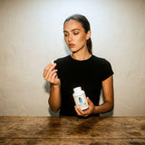 Botella Dear Apothecary junto a una regla para comparar tamaño y porción de 60 cápsulas
