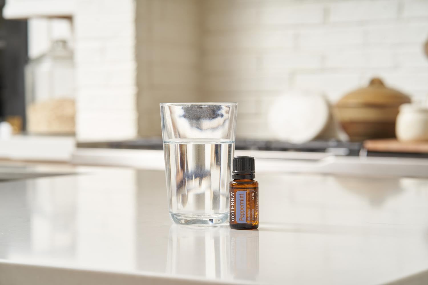doTERRA botella junto a monedas y llaves para comparar tamaño 15 ml