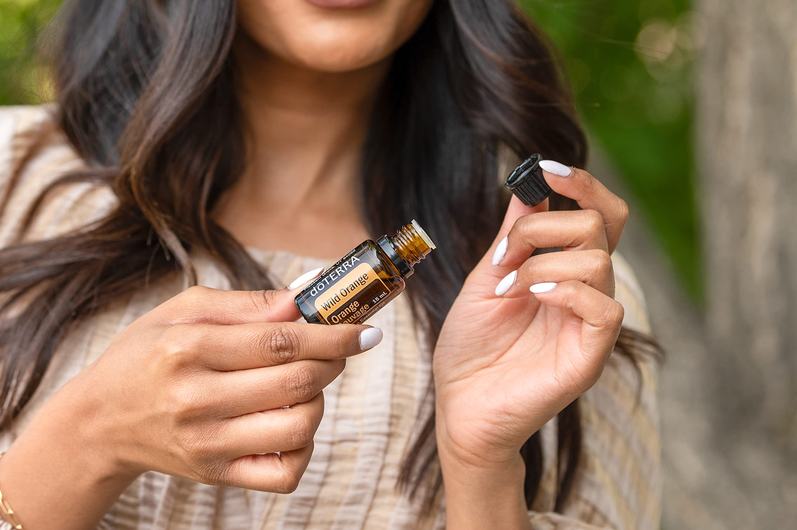doTERRA gotas de Wild Orange en manos demostrando aplicación tópica segura
