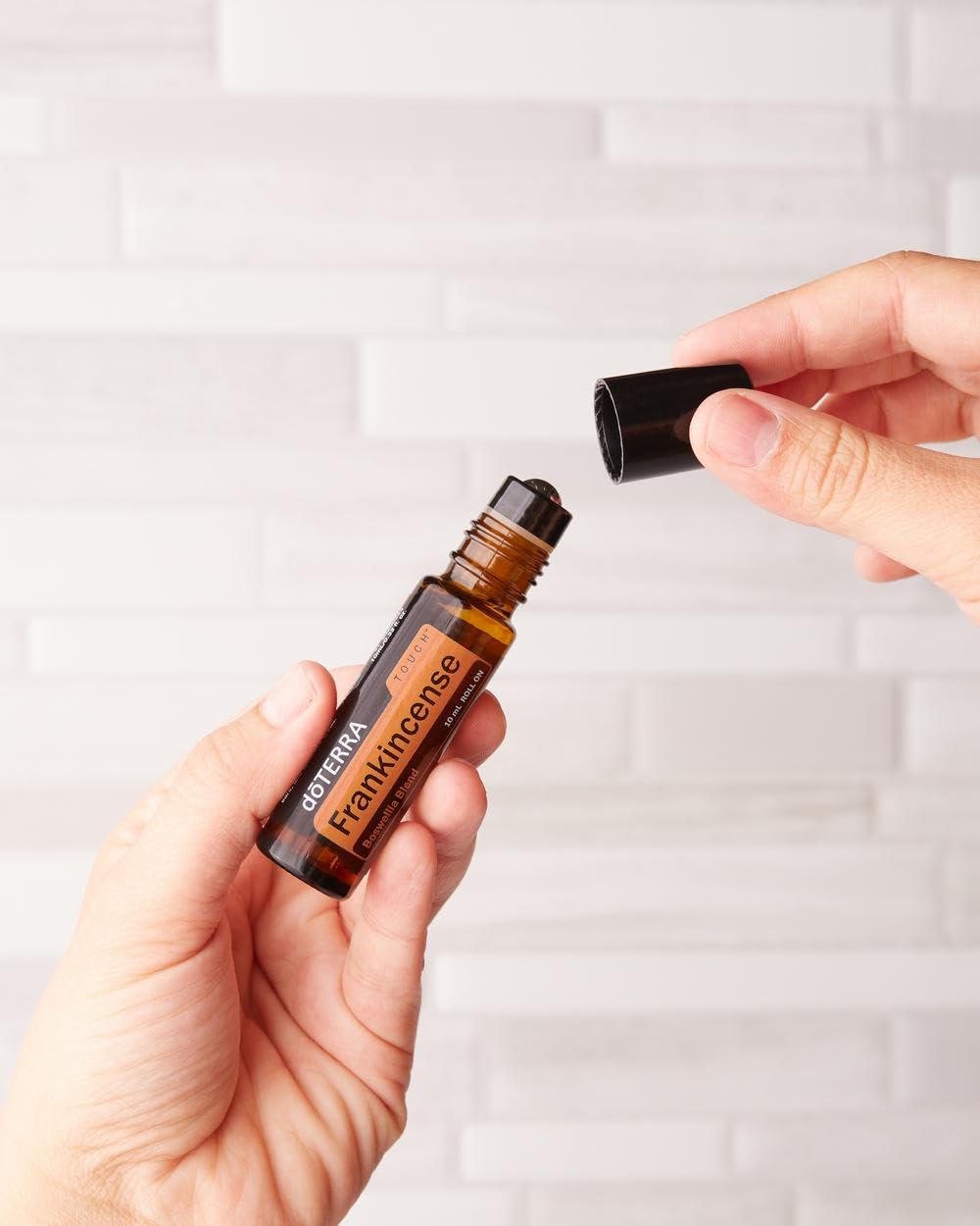 doTERRA roll-on Frankincense en muñeca mostrando aplicación portátil y cómoda