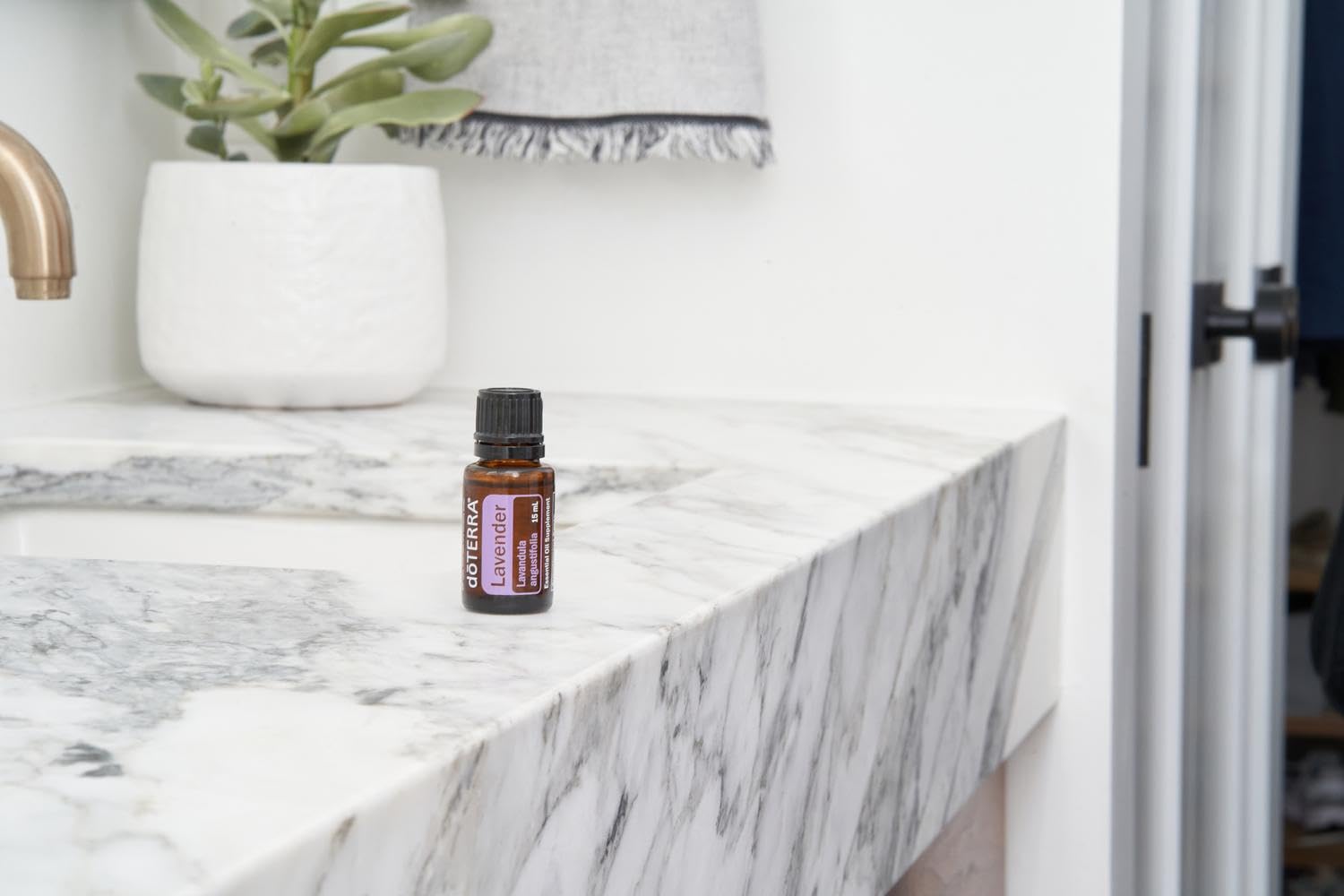 doTERRA frasco en mano para comparar tamaño y facilidad de transporte