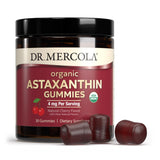 Dr. Mercola gominola en mano para mostrar tamaño y dosis diaria