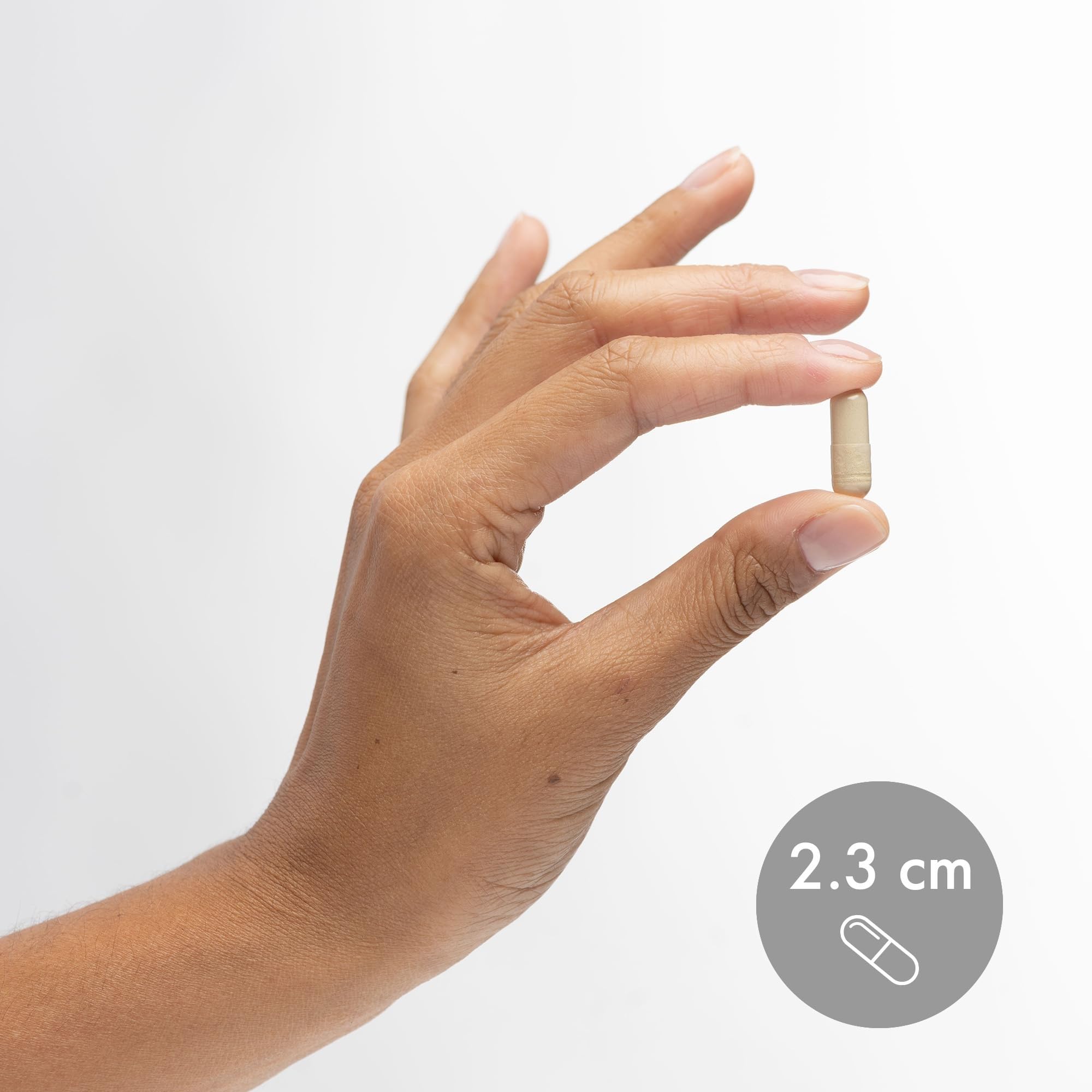 Cápsula de Dr. Mercola en la mano para comparar tamaño y facilidad