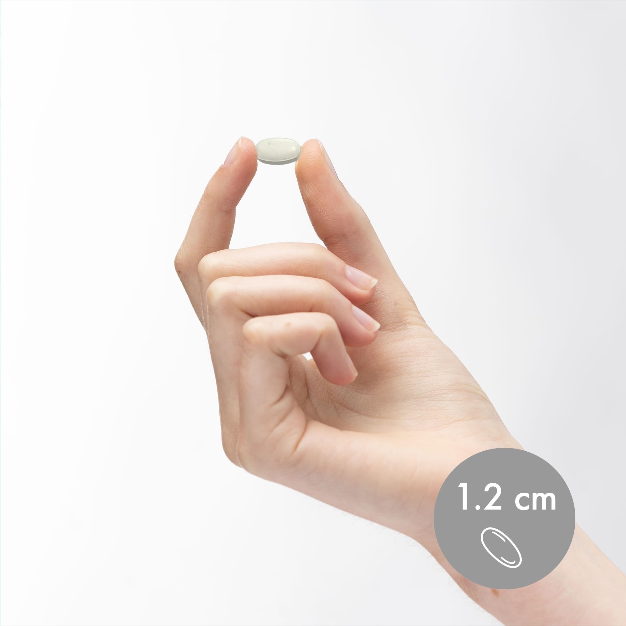 Dr. Mercola mini tabletas en mano demostrando dosis práctica