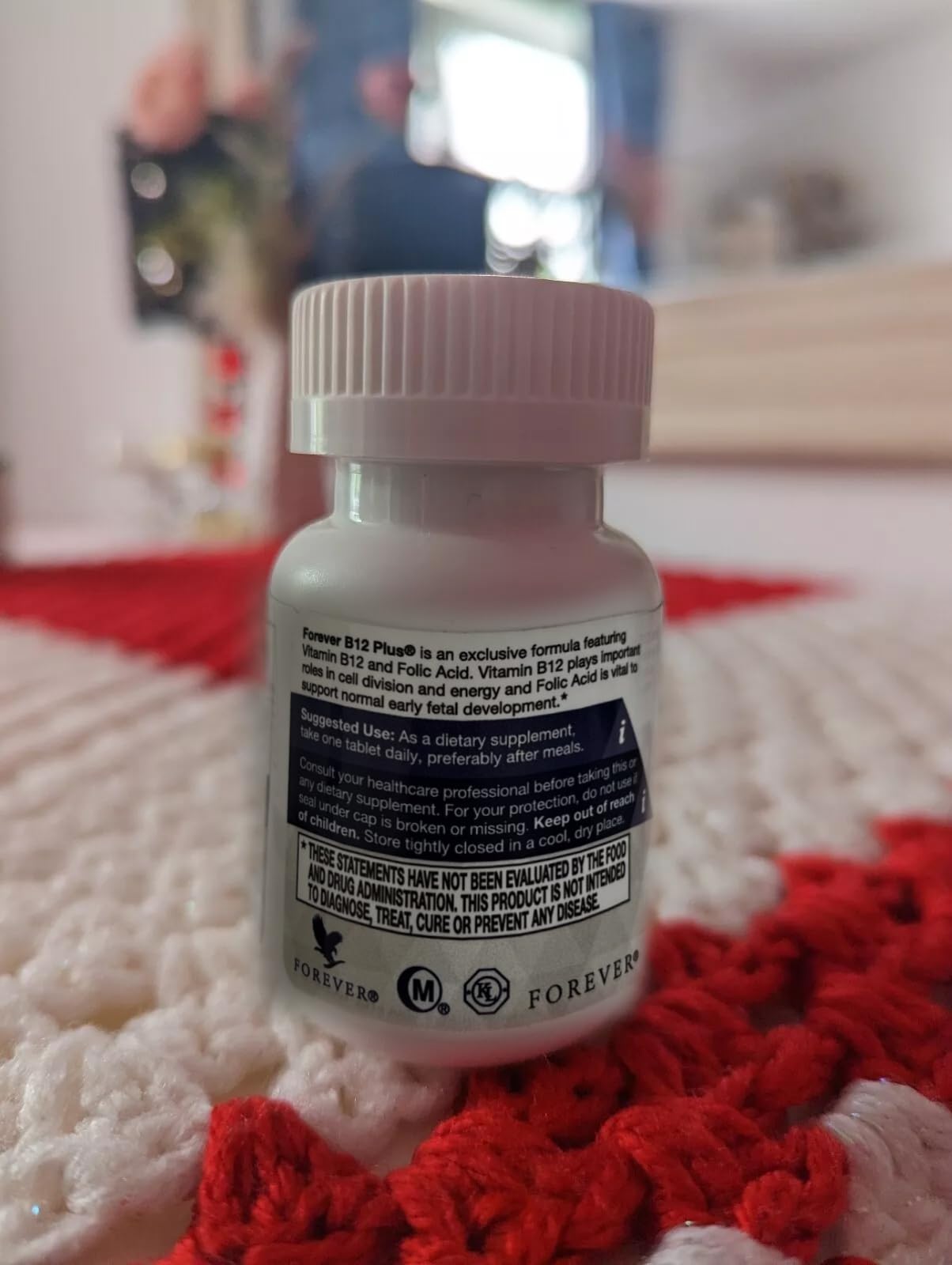 Forever Living B12 Plus botella sobre mesa de cocina sugiere uso cotidiano simple