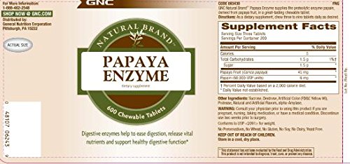 GNC tabletas en mesa junto a fruta papaya ilustrando uso con comidas