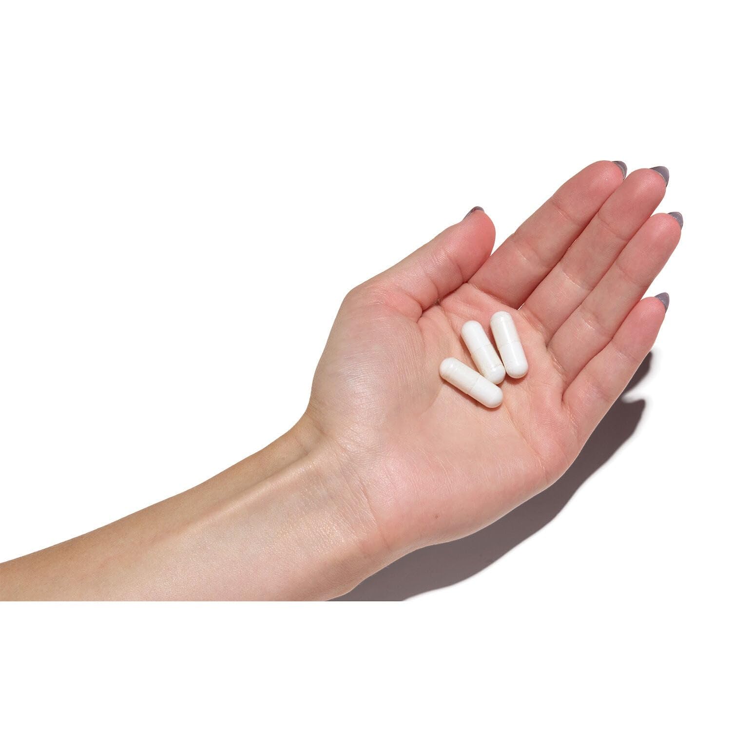 bote de GNC Super Magnesium en mano para comparar tamaño y porción