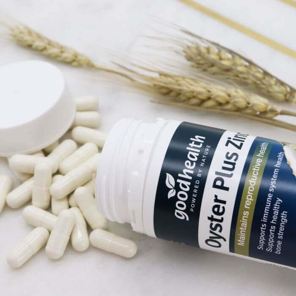 Goodhealth Oyster Plus cápsula junto a moneda para comparar tamaño