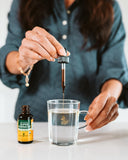 Botella Herb Pharm frente a plantas de Echinacea en la granja certificada mostrando origen