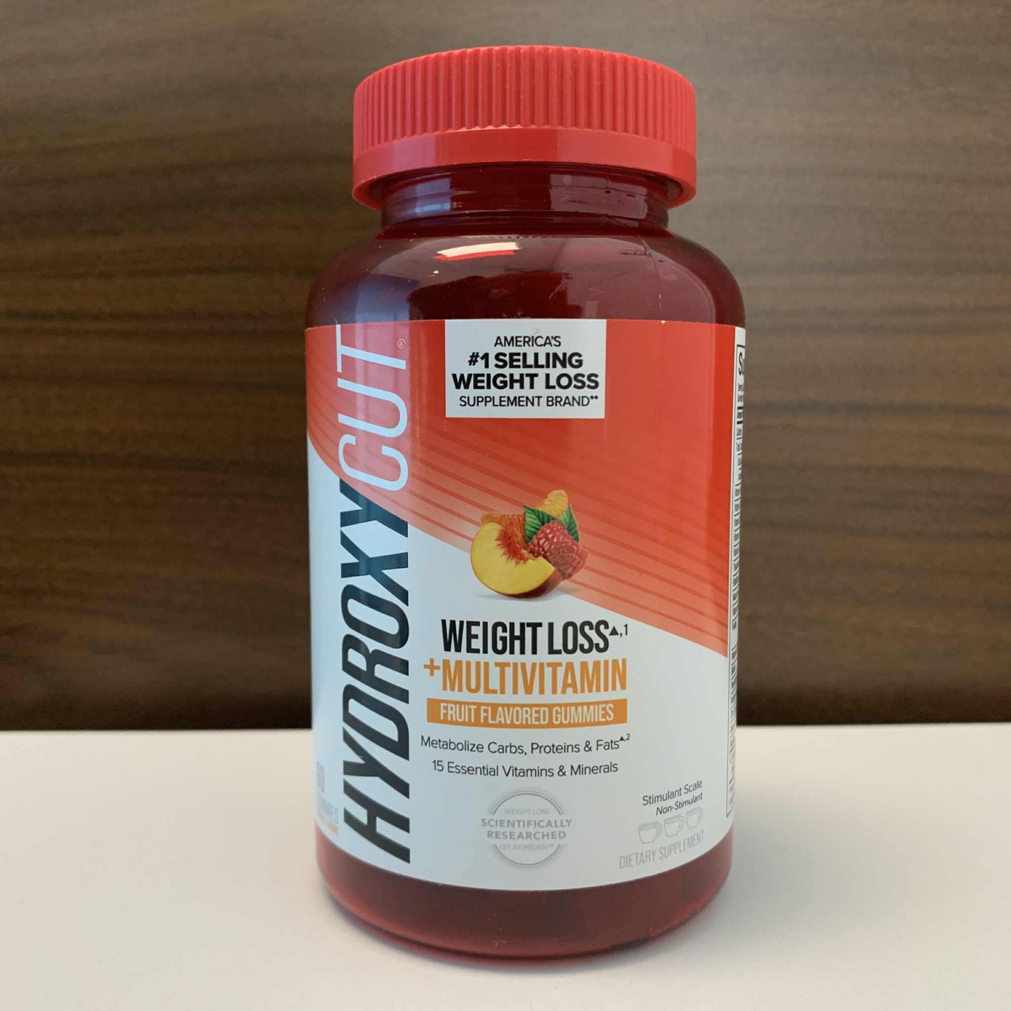 Hydroxycut gomita en la mano para comparar tamaño y facilitar dosis
