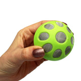 Kavafied AluBall junto a una mano para comparar tamaño portátil