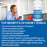 cápsula Kidney Shield entre dedos para comparar tamaño y facilidad de ingesta