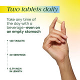 MegaFood tabletas junto a un vaso de agua para facilidad de toma