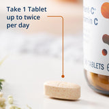 Metagenics Ultra Potent-C tableta junto a vaso de agua, uso diario sencillo y cómodo