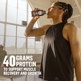 Comparación de tamaño de Muscle Milk Pro junto a una mano para referencia de porción