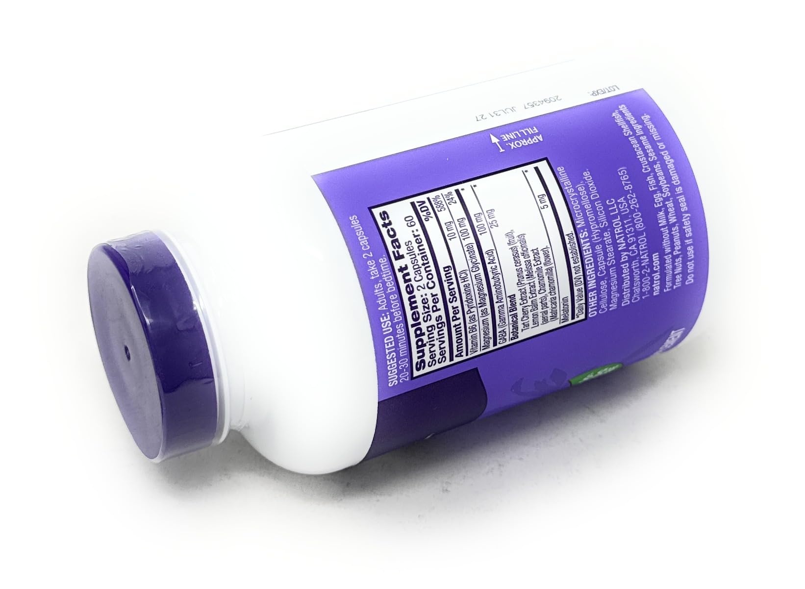 Natrol frasco junto a mesita de noche sugiriendo rutina nocturna relajante