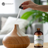 NaturoBliss botella 4 fl. oz junto a una regla para comparar tamaño