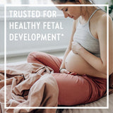 Mujer embarazada tomando New Chapter Perfect Prenatal para apoyo nutricional