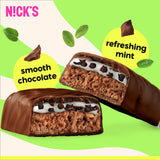 N!CK'S barra en mano junto a pesas, práctico snack proteico para entrenar