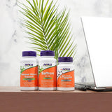 NOW Foods cápsulas junto a moneda para comparar tamaño y escala
