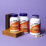 NOW Foods cápsula junto a monedas para comparar tamaño, referencia visual clara