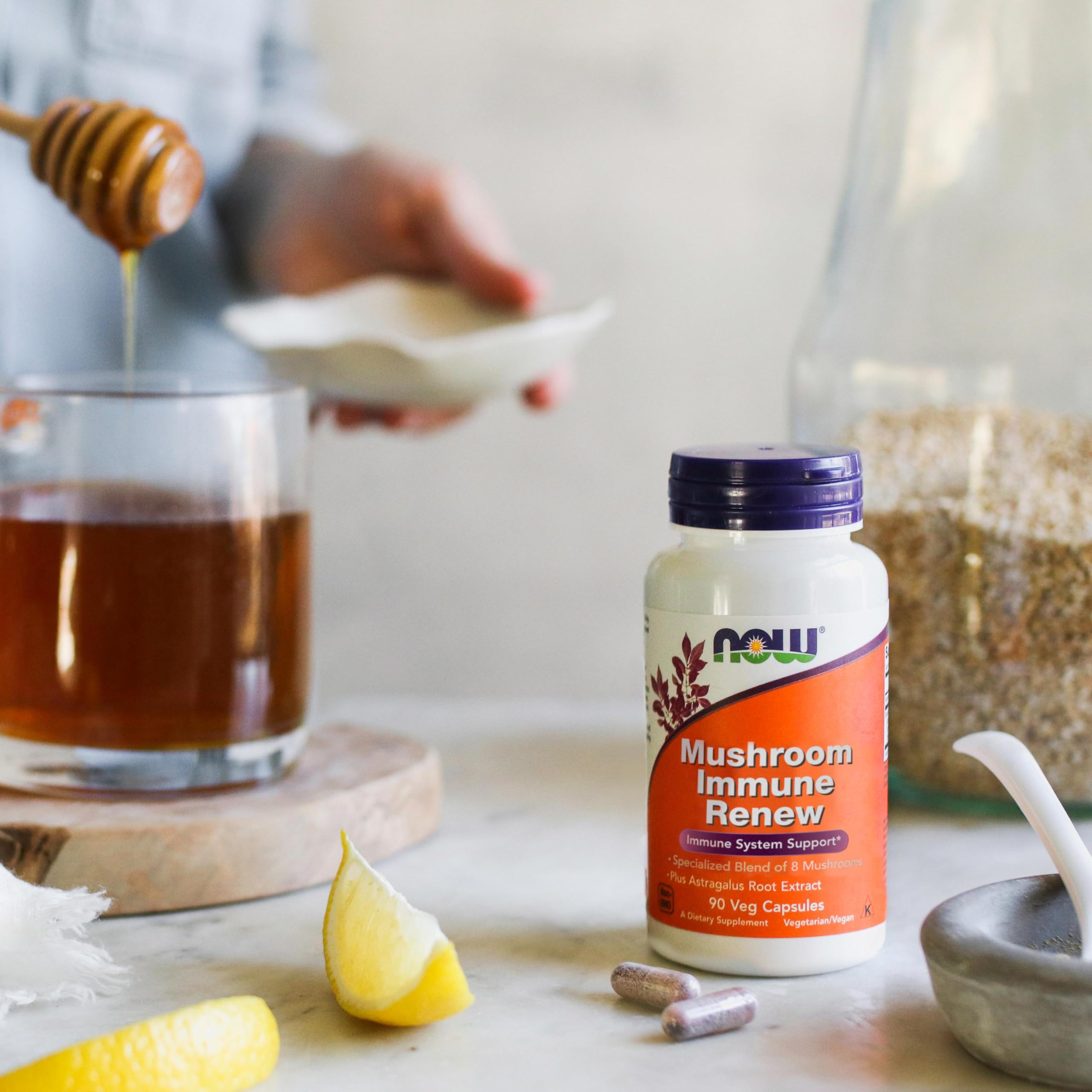 NOW Foods botella junto a mano para comparar tamaño y cantidad