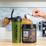 Bote de NutraBio Intra Blast sobre banco de gimnasio preparado para uso