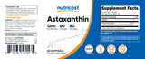 Frasco de Nutricost astaxanthin en entorno saludable con frutas y toalla