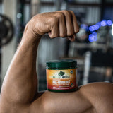 Bote de Organic Muscle junto a una botella para comparar tamaño y raciones
