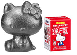OSK Hello Kitty comparada con una cuchara, muestra el tamaño compacto y portátil