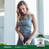 Piping Rock cápsulas vegetarianas mostradas listas para tomar con vaso de agua