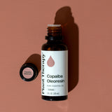 Plant Therapy frasco de Copaiba junto a moneda para comparar tamaño real