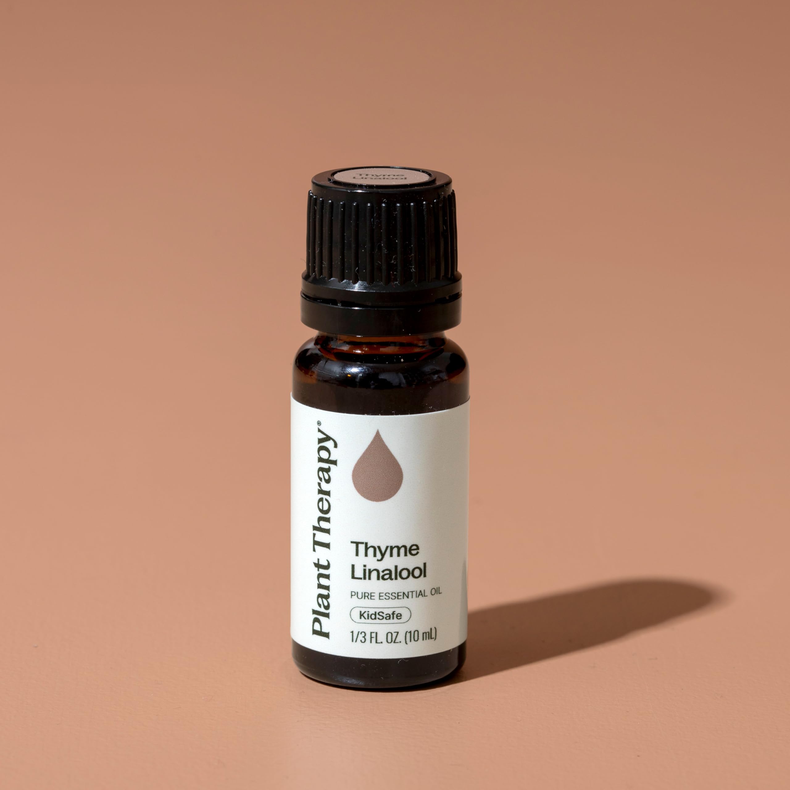 Plant Therapy frasco junto a una moneda para comparar tamaño compacto de 10 mL