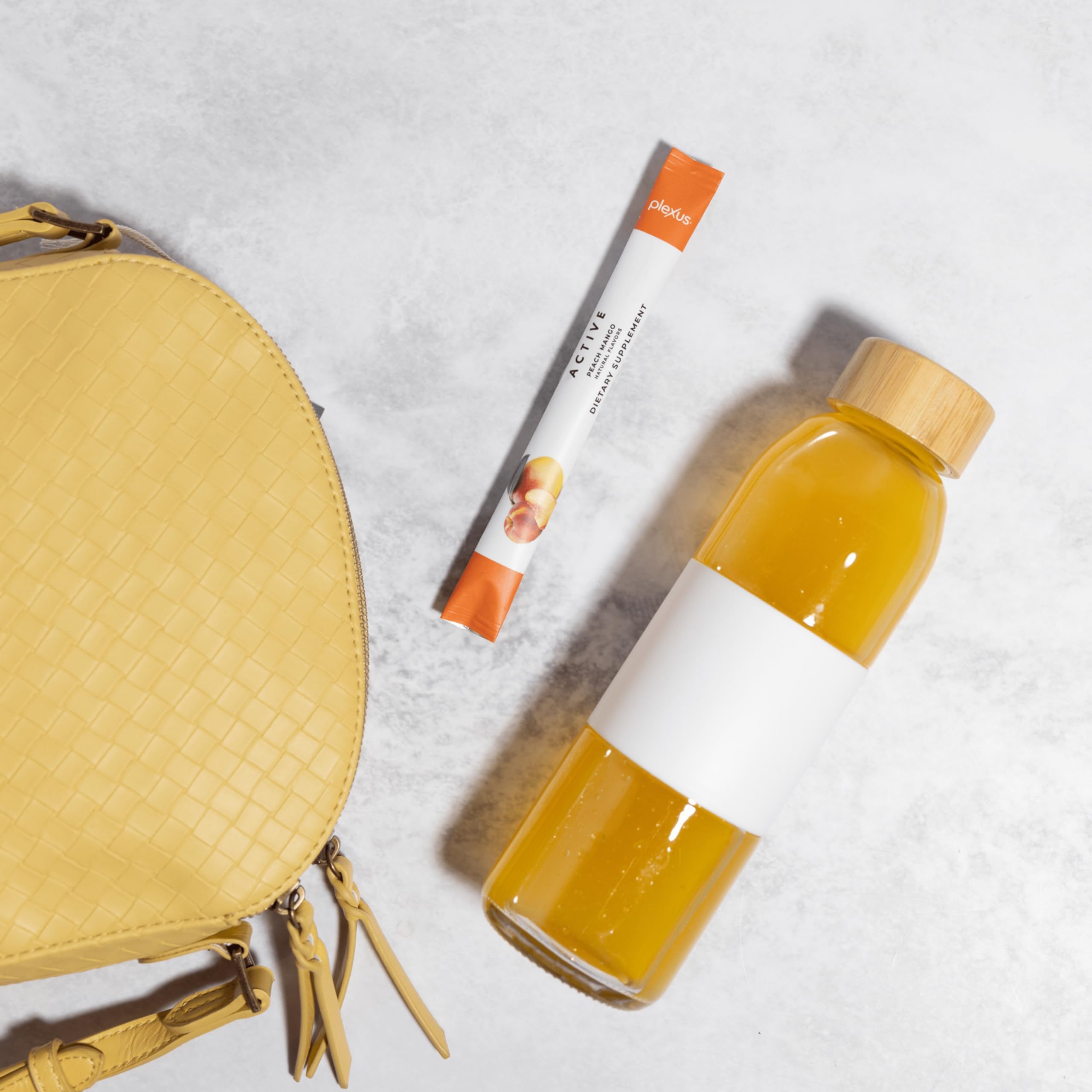 Envase Plexus Active junto a una mano para comparar tamaño y porción