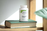 Professional Complementary Health Formulas cápsula en mano junto a calendario de uso diario