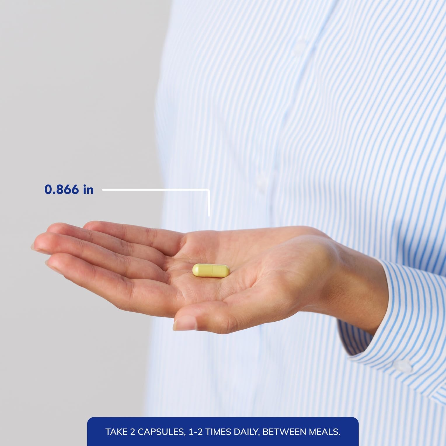 Pure Encapsulations comparación de tamaño de cápsula junto a una moneda para escala