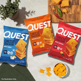 Quest crackers junto a una botella y toalla en el gimnasio, snack alto en proteína