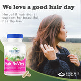 Frasco de RidgeCrest Herbals Hair ReVive comparado con una mano para referencia de tamaño