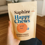 SAPHIRE HAPPY CHEWS frasco junto a desayuno ilustrando uso diario rutinario