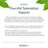 Shaklee Vita-E cápsula en mano junto a comida para uso diario sencillo