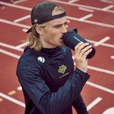 Smartshake Reforce en gimnasio junto a toalla y pesa, lista para entreno
